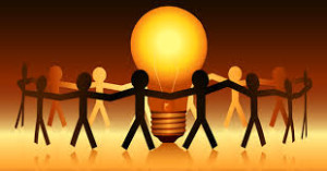 cut out figures holding hands and circling a lit lightbulb
